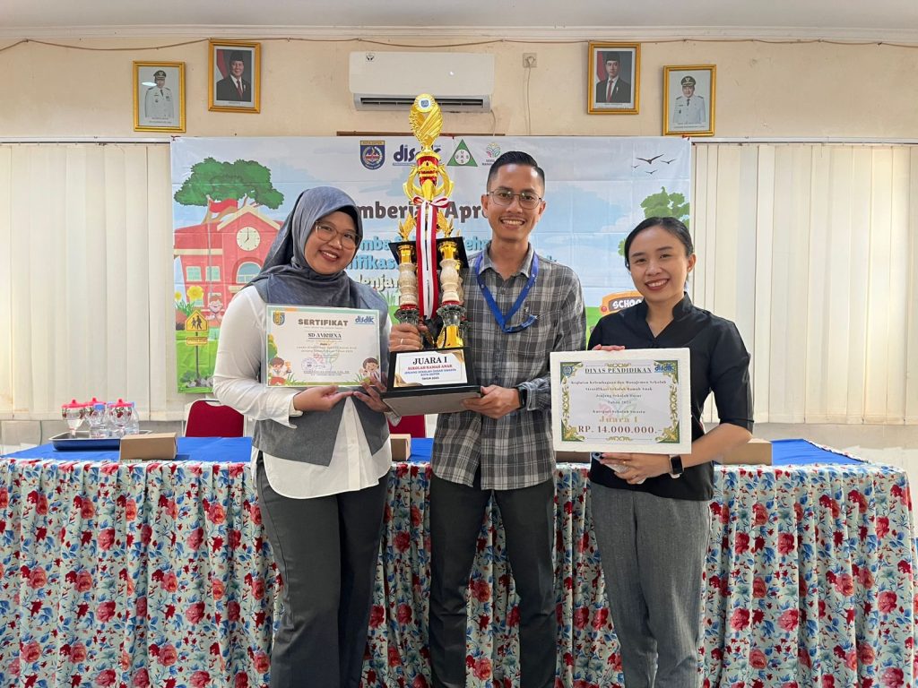 Foto kepala sekolah dan Psikolog SD Avicenna Cinere memegang piala dan piagam penghargaaan